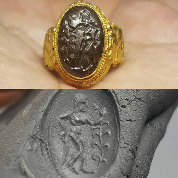 Roman style gold intaglio ring with a large engraved garnet showing woman holding a branch